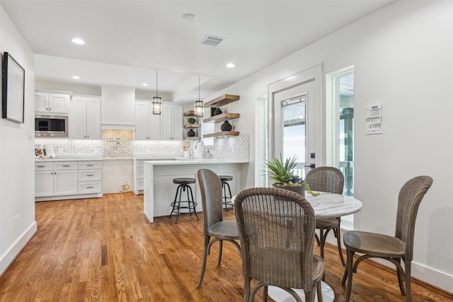 dining room with light wood-style flooring, recessed lighting, baseboards, and visible vents