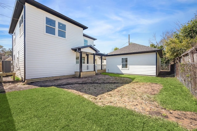 back of property featuring a yard, central AC unit, and fence