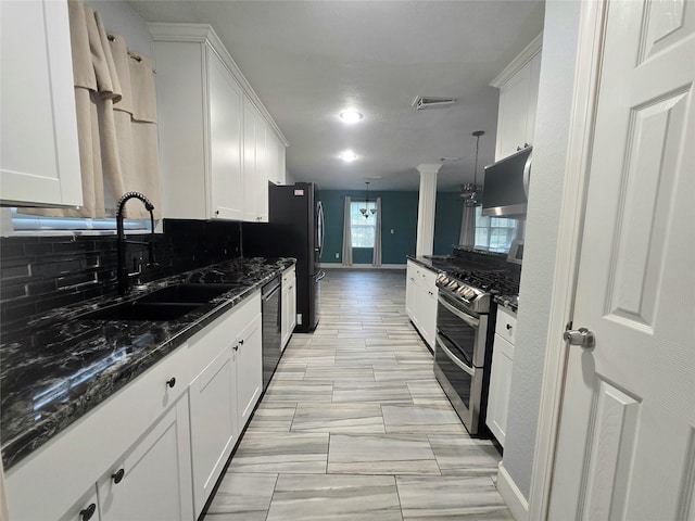 kitchen with a sink, white cabinetry, and double oven range