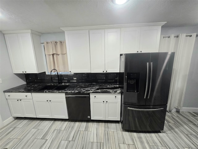 kitchen with a sink, white cabinetry, stainless steel refrigerator with ice dispenser, decorative backsplash, and dark stone counters