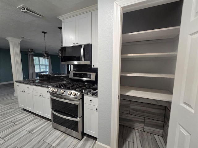 kitchen with stainless steel appliances, dark stone countertops, open shelves, and white cabinets