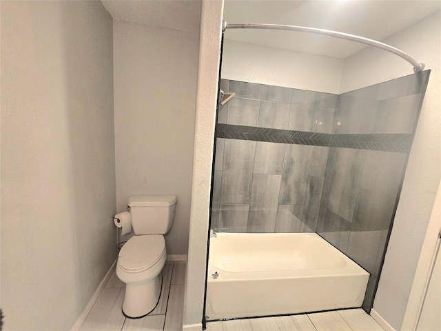 full bathroom with tub / shower combination, toilet, and baseboards