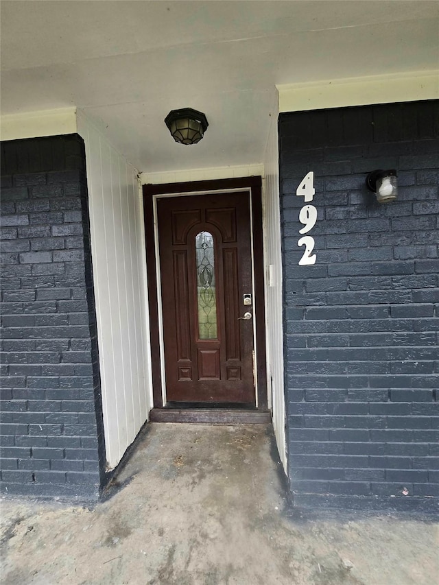 view of exterior entry featuring brick siding