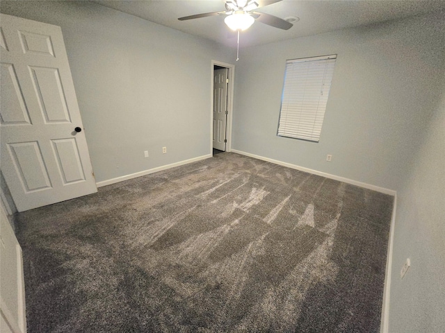 unfurnished bedroom featuring baseboards, dark colored carpet, and a ceiling fan