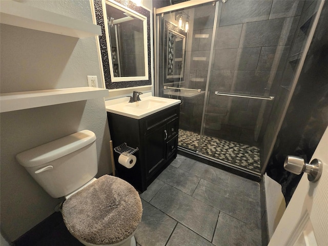 full bath with a stall shower, a textured wall, vanity, and toilet