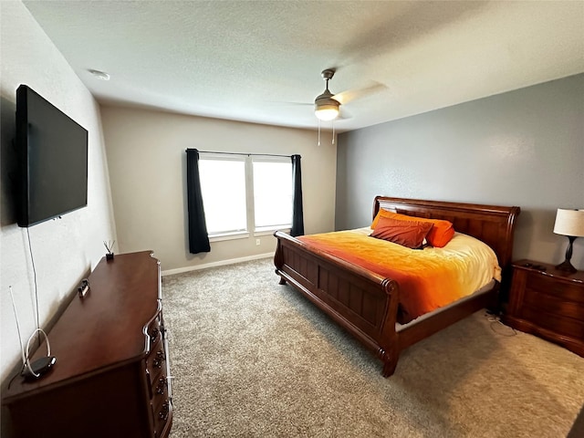 bedroom with a textured ceiling, ceiling fan, carpet, and baseboards