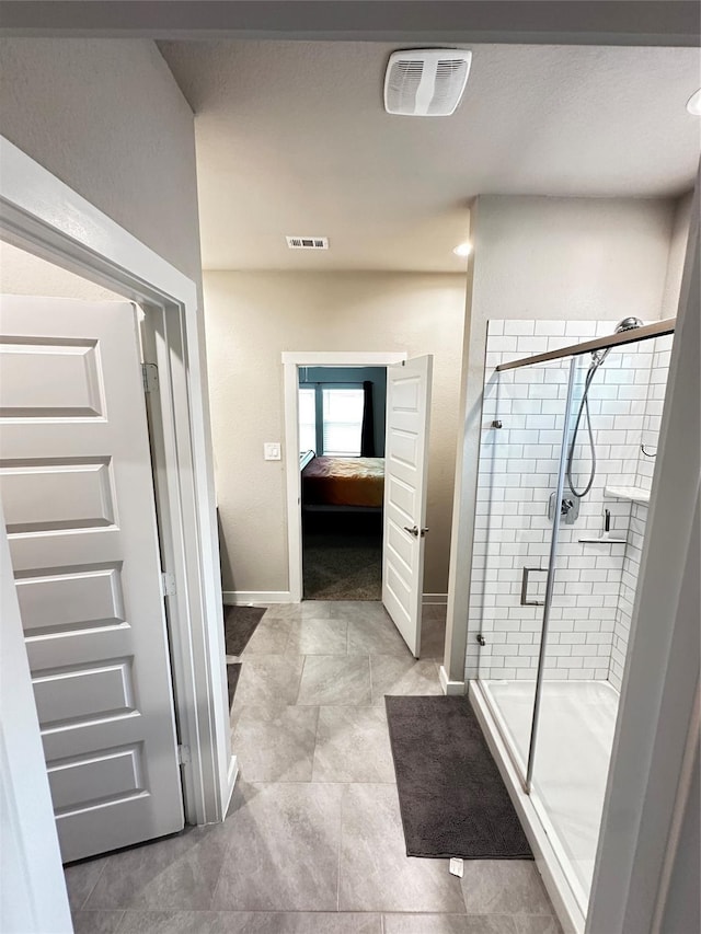 bathroom featuring a stall shower, visible vents, baseboards, and ensuite bathroom