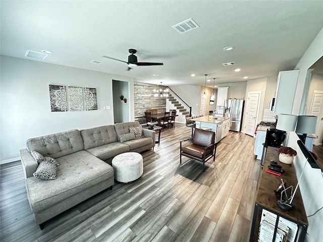 living area featuring light wood-style floors, stairs, visible vents, and recessed lighting