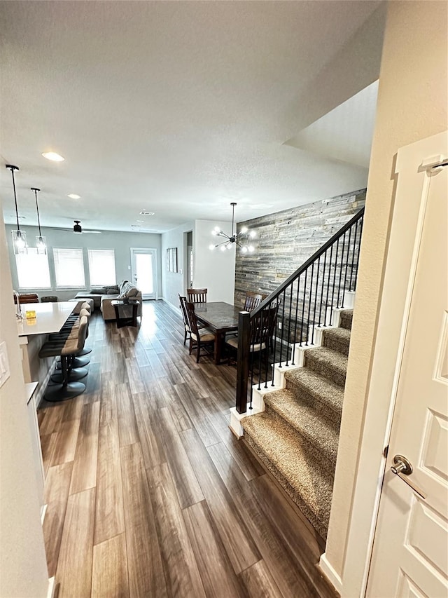 stairway with a chandelier and wood finished floors