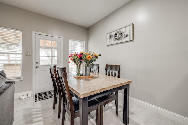 dining space featuring light tile patterned floors and baseboards