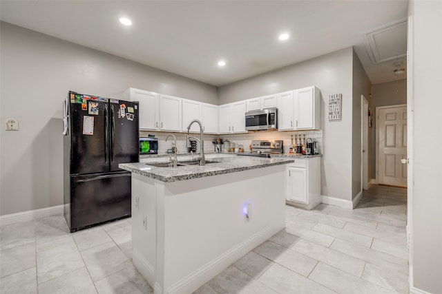 kitchen with an island with sink, white cabinetry, appliances with stainless steel finishes, and a sink