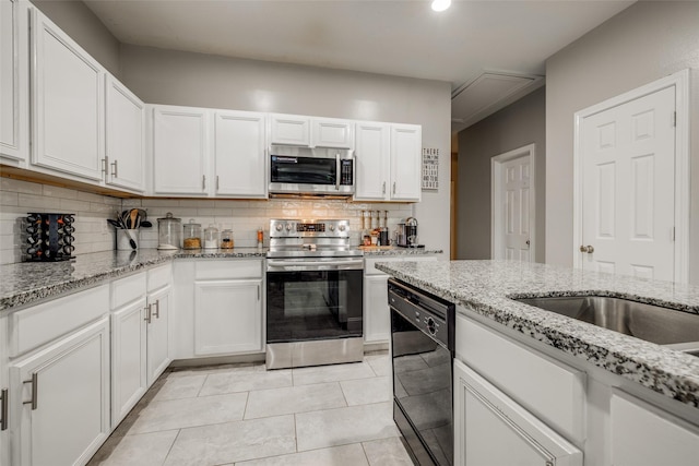 kitchen featuring white cabinets, light stone countertops, tasteful backsplash, and stainless steel appliances