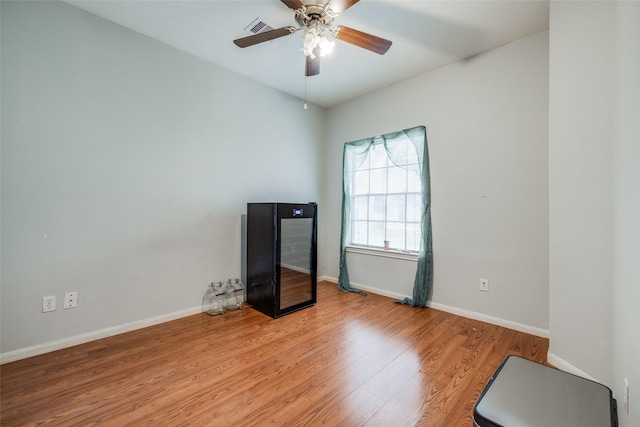 interior space featuring light wood-style floors, visible vents, baseboards, and a ceiling fan