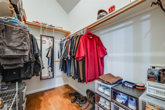 walk in closet with vaulted ceiling and wood finished floors