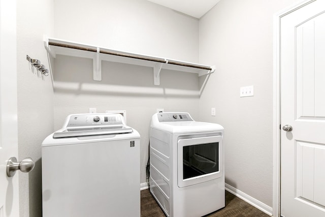 washroom with dark wood-type flooring, laundry area, baseboards, and separate washer and dryer