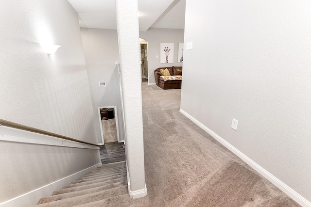 stairs with carpet floors, visible vents, and baseboards