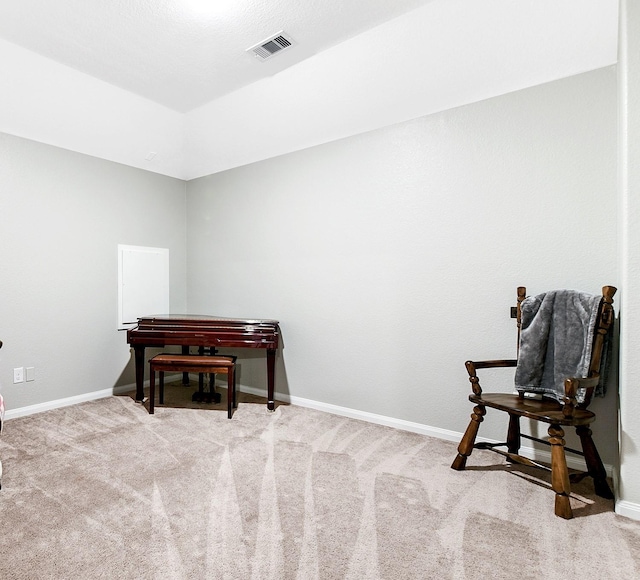 living area featuring light colored carpet, visible vents, and baseboards