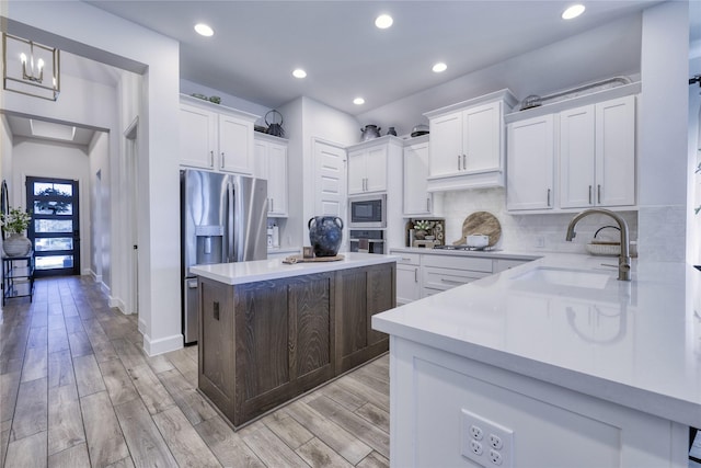 kitchen featuring a sink, light countertops, appliances with stainless steel finishes, and white cabinets