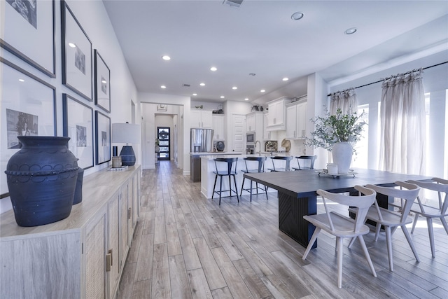 dining space featuring light wood finished floors and recessed lighting