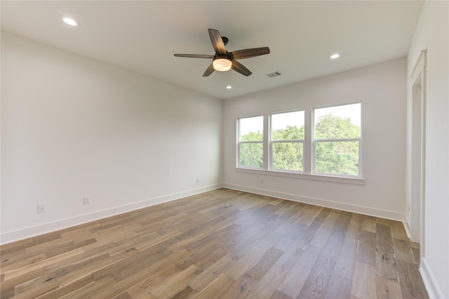 empty room with light wood-type flooring, visible vents, baseboards, and recessed lighting