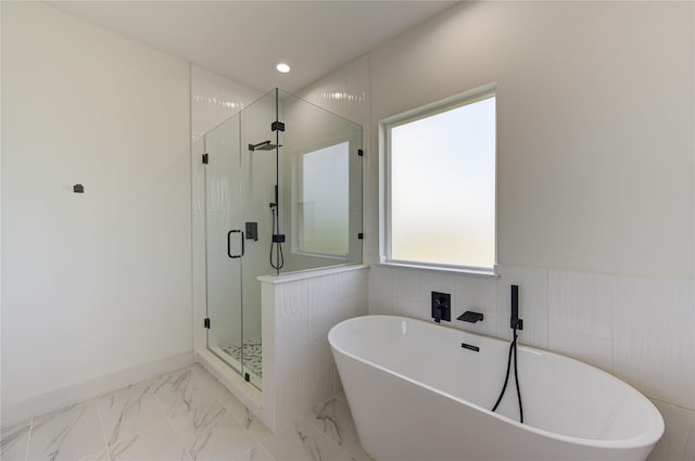 bathroom featuring a wainscoted wall, a soaking tub, recessed lighting, a shower stall, and marble finish floor