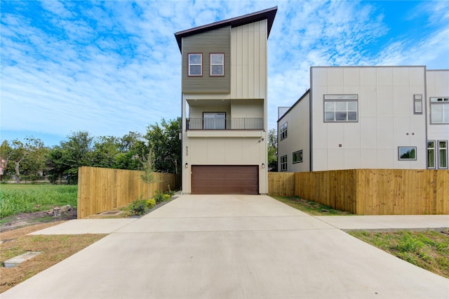 modern home featuring fence, a garage, and driveway