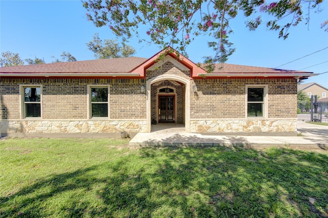 view of front of house featuring a front yard, stone siding, and brick siding