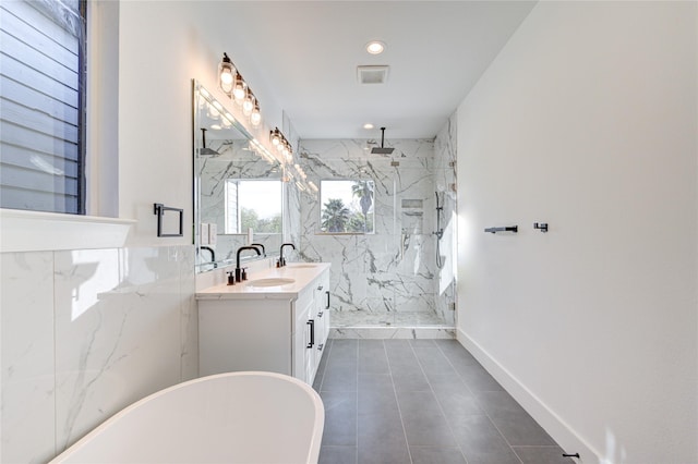 full bath with double vanity, a marble finish shower, visible vents, a soaking tub, and a sink