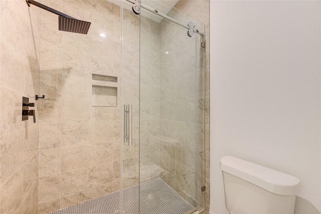 bathroom with a shower stall and toilet