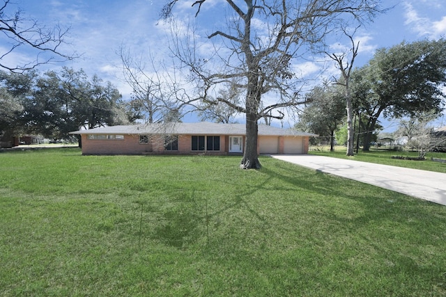 view of front facade with a front yard, concrete driveway, brick siding, and an attached garage