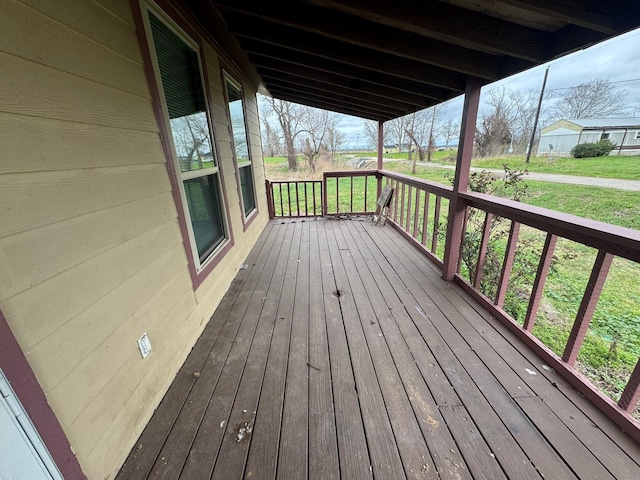 wooden deck featuring a lawn