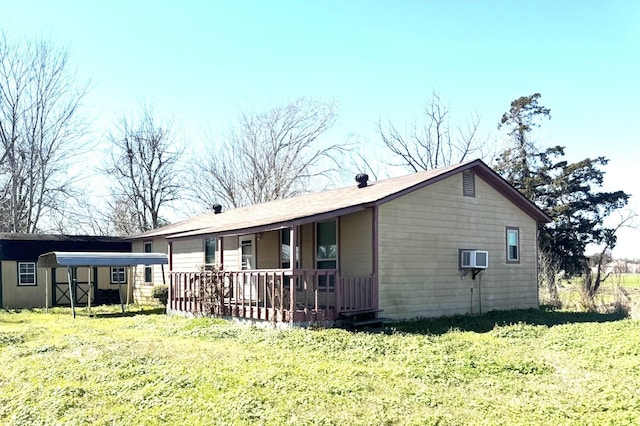 exterior space featuring a carport, a lawn, and an outbuilding