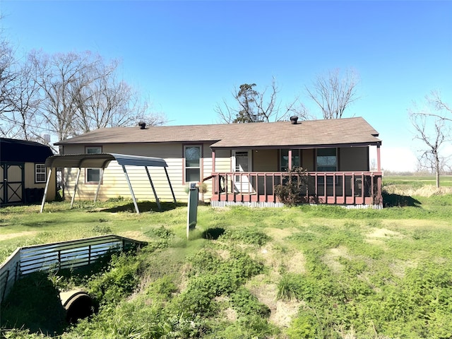 rear view of house featuring a storage shed, an outbuilding, a lawn, and a detached carport