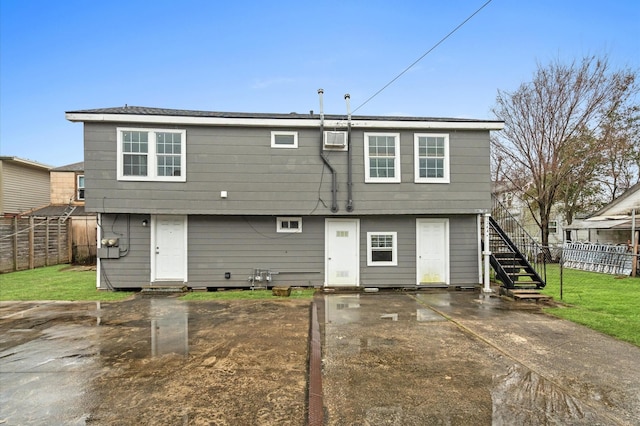 back of house featuring entry steps, a wall mounted air conditioner, fence, and stairs