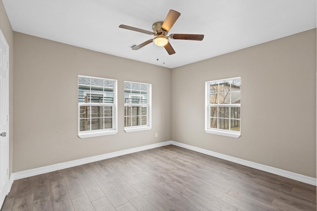 spare room featuring ceiling fan, baseboards, and wood finished floors