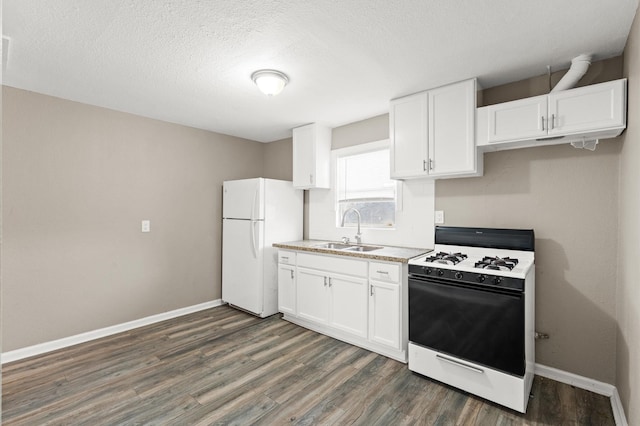 kitchen featuring a sink, white cabinetry, baseboards, freestanding refrigerator, and range with gas cooktop