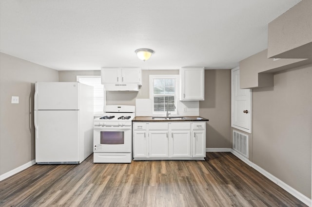 kitchen featuring white appliances, visible vents, dark wood-style floors, white cabinetry, and a sink