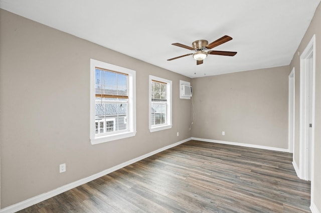 spare room with dark wood finished floors, a ceiling fan, and baseboards