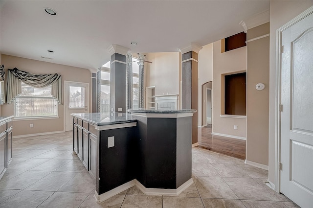 kitchen featuring visible vents, a kitchen island, baseboards, and light tile patterned flooring