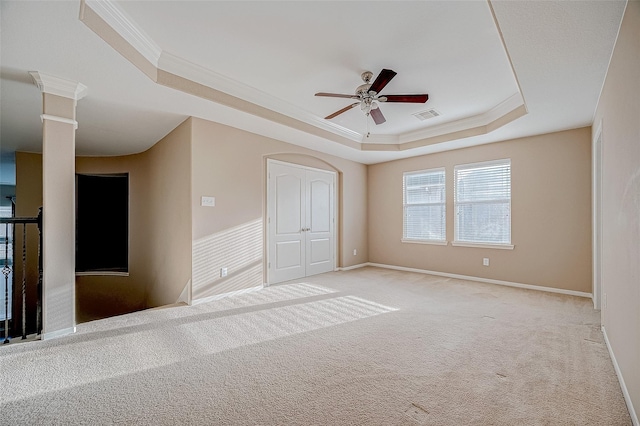 unfurnished room with light carpet, a tray ceiling, visible vents, and crown molding