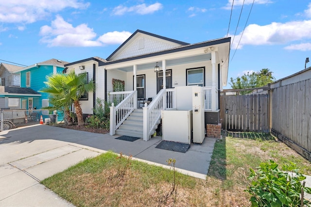 view of front of house featuring fence and a porch