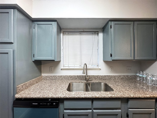 kitchen with gray cabinetry, dishwasher, and a sink