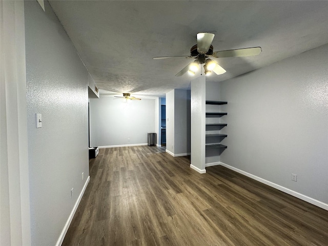 interior space with dark wood-style floors, baseboards, and a ceiling fan