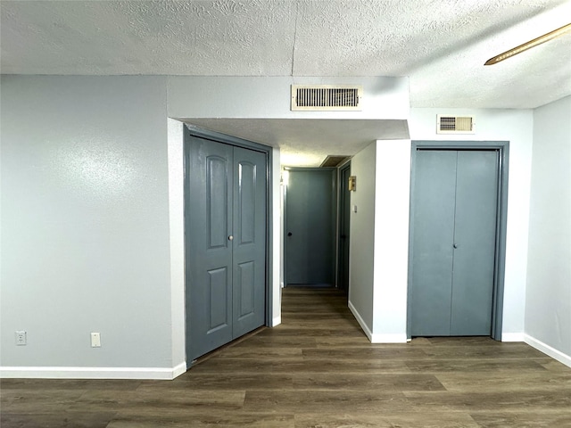 interior space featuring dark wood-style flooring, visible vents, and baseboards