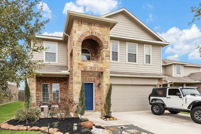 view of front of home featuring an attached garage, stone siding, concrete driveway, and brick siding