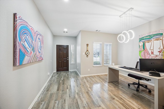 home office featuring light wood-style floors, visible vents, and baseboards