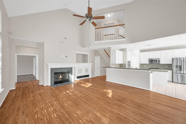 unfurnished living room featuring visible vents, a fireplace, and light wood finished floors