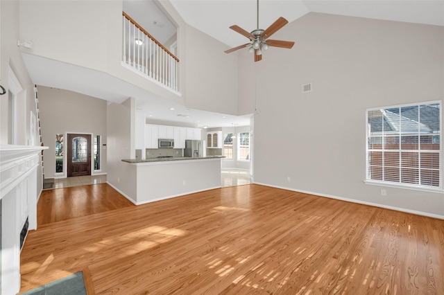 unfurnished living room with baseboards, light wood finished floors, visible vents, and a ceiling fan