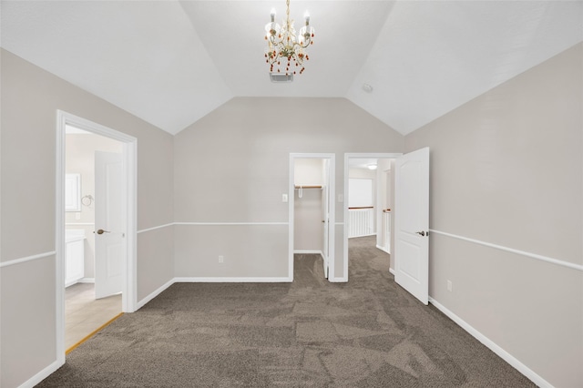 interior space with visible vents, a spacious closet, carpet flooring, vaulted ceiling, and baseboards