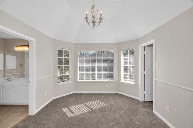 spare room with carpet floors, baseboards, vaulted ceiling, and a sink